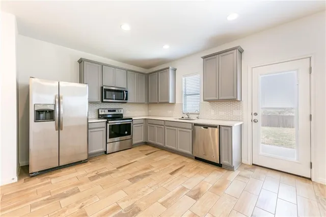 a kitchen with a refrigerator sink and cabinets