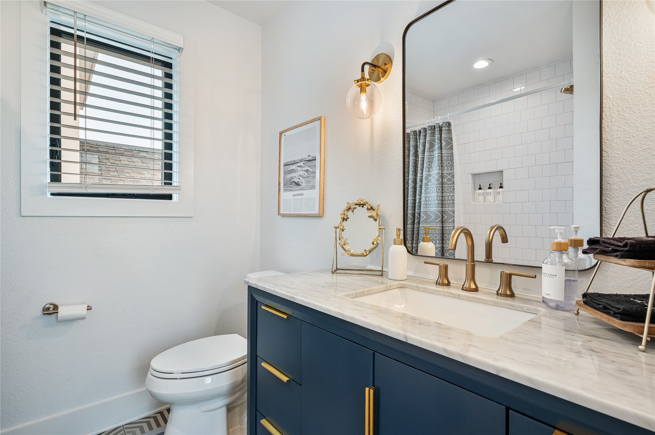 3817 Avenue R Galveston, TX 77550 - Photo 17 of 35 a bathroom with a granite countertop sink toilet and mirror