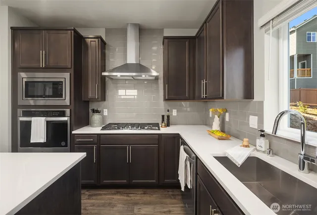 a kitchen with stainless steel appliances granite countertop a sink stove and refrigerator