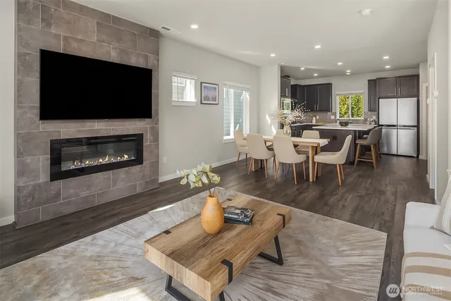 a living room with furniture a flat screen tv and kitchen view