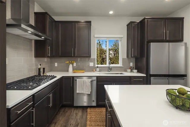 a kitchen with stainless steel appliances granite countertop a sink stove and refrigerator