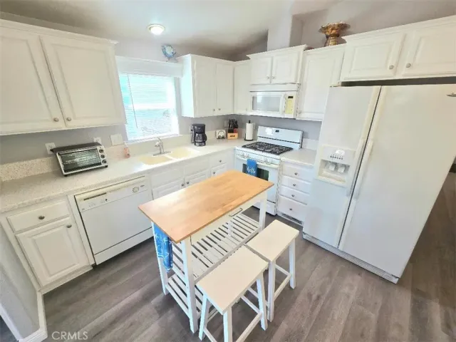 a kitchen with white cabinets and white appliances