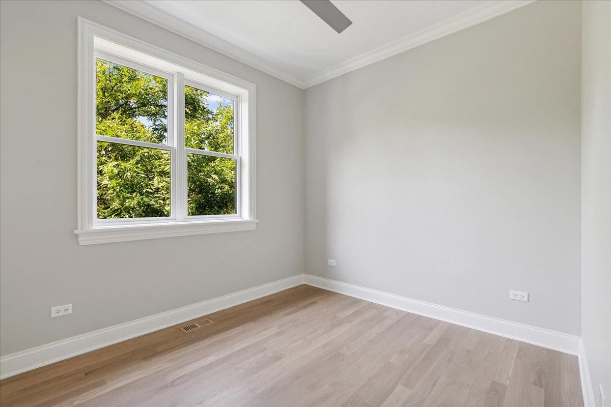 1457 West Roscoe Street, Unit 2 Chicago, IL 60657 - Photo 11 of 16 an empty room with wooden floor and windows
