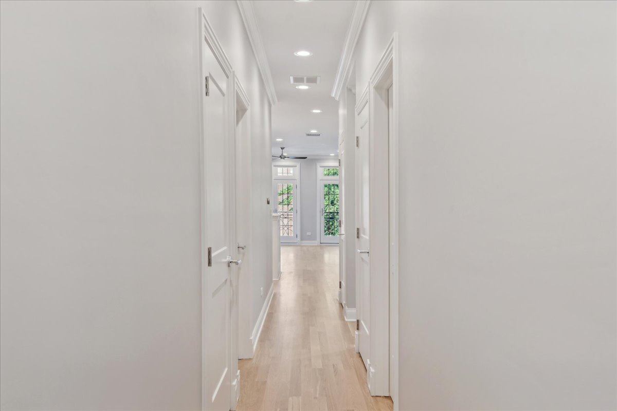 1457 West Roscoe Street, Unit 2 Chicago, IL 60657 - Photo 12 of 16 a view of a hallway with wooden floor and a bathroom