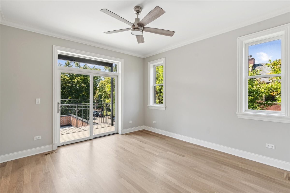 1457 West Roscoe Street, Unit 2 Chicago, IL 60657 - Photo 13 of 16 an empty room with wooden floor and windows
