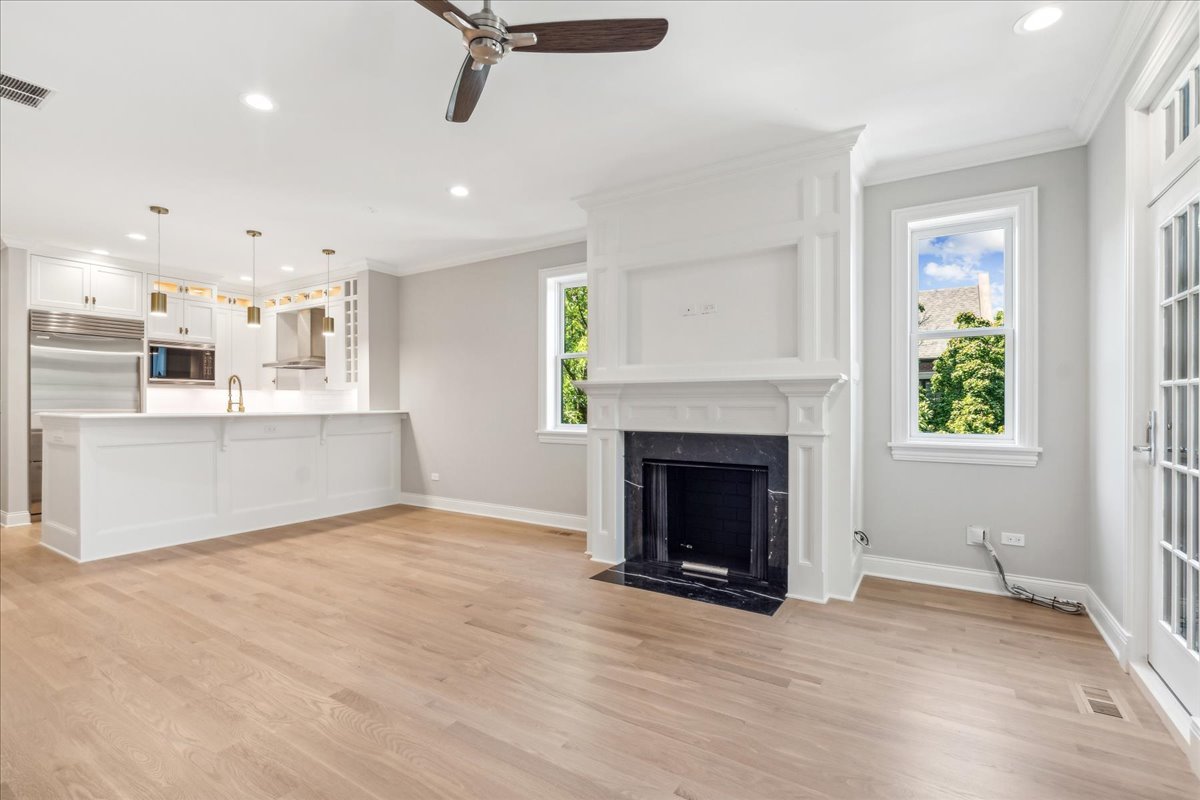 1457 West Roscoe Street, Unit 2 Chicago, IL 60657 - Photo 2 of 16 an empty room with kitchen and fireplace