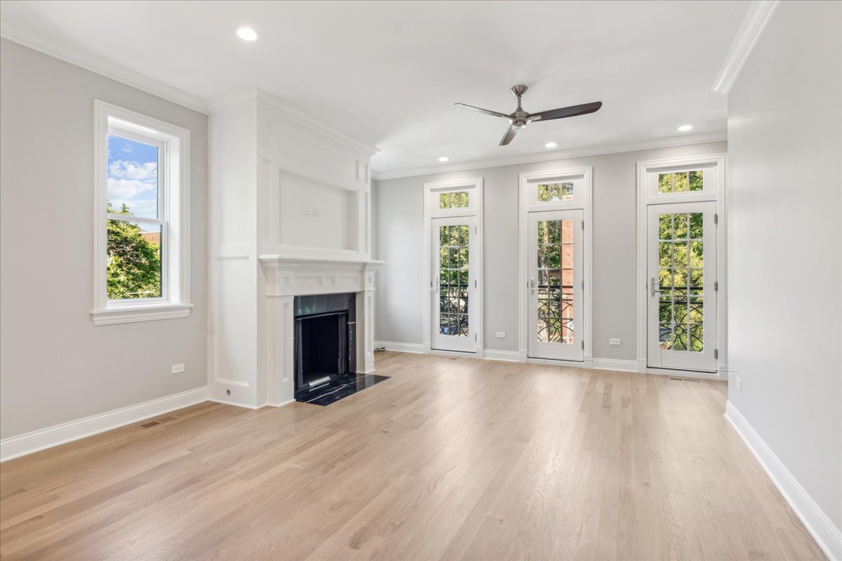 1457 West Roscoe Street, Unit 2 Chicago, IL 60657 - Photo 3 of 16 wooden floor fireplace and windows in an empty room