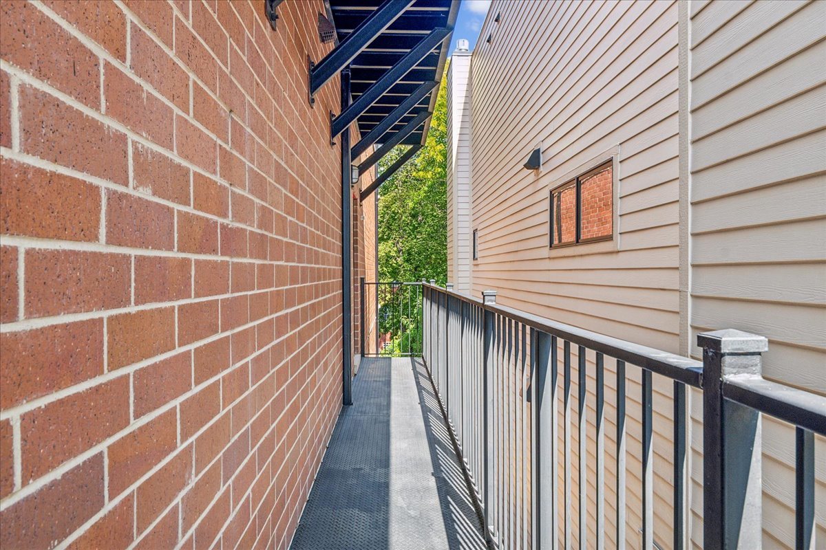 1457 West Roscoe Street, Unit 2 Chicago, IL 60657 - Photo 8 of 16 a view of a balcony with wooden floor and fence