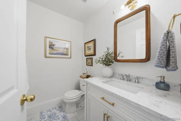 a bathroom with a granite countertop toilet a sink and a mirror