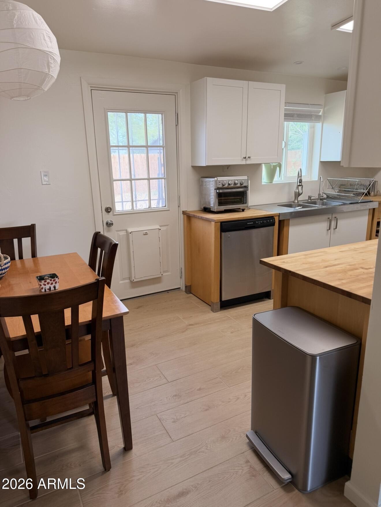 512 West 17th Street Tempe, AZ 85281 - Photo 6 of 13 a kitchen with a table chairs a sink dishwasher window and cabinets