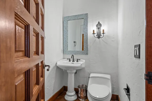 a bathroom with a toilet sink and mirror