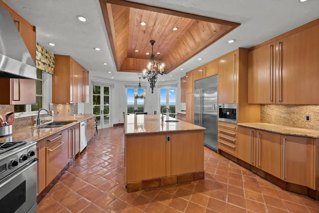 a large kitchen with kitchen island a sink stainless steel appliances and cabinets