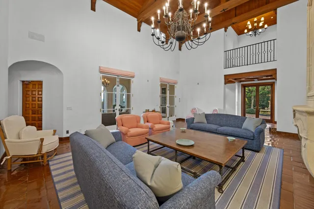 a living room with furniture a chandelier and a window