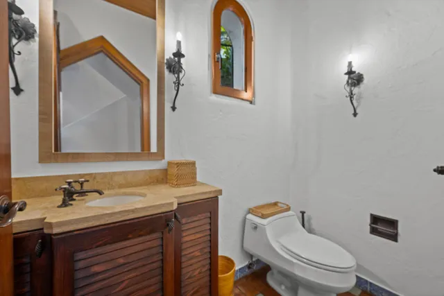 a bathroom with a toilet a sink and mirror
