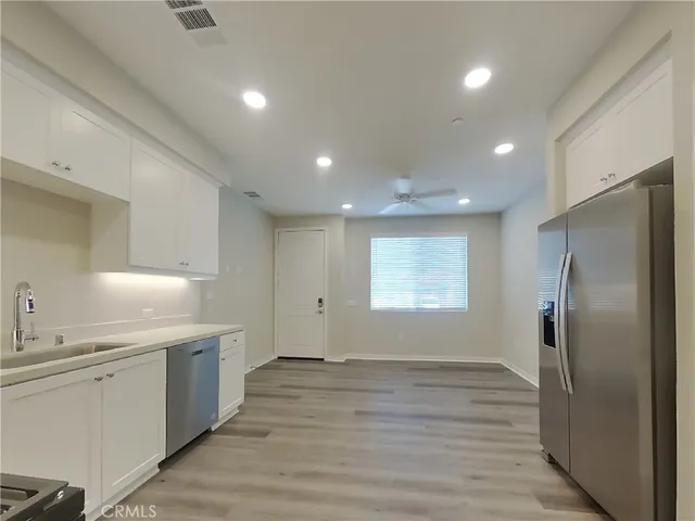 a kitchen with stainless steel appliances a refrigerator sink and cabinets