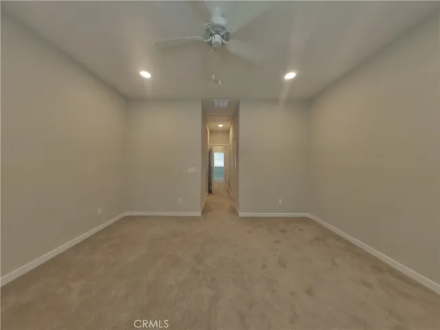 an empty room with closet and a chandelier fan
