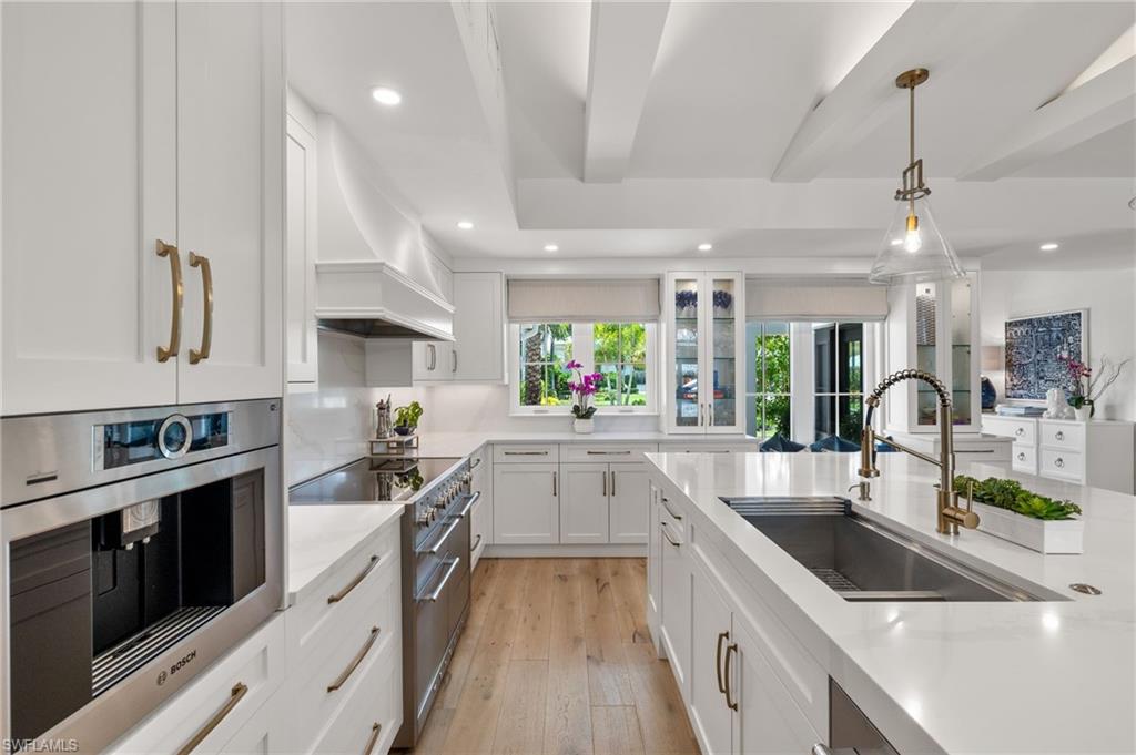 1960 Tarpon Road Naples, FL 34102 - Photo 14 of 49 a kitchen with stainless steel appliances a sink stove and cabinets