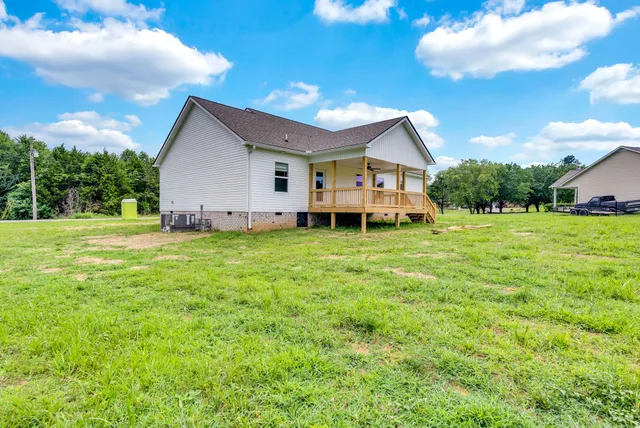 a view of a house with a big yard and large trees