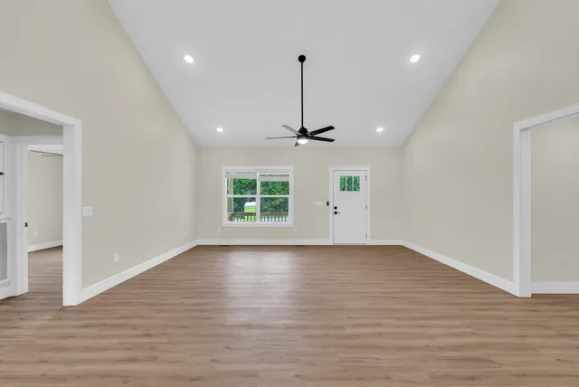 a view of a house with a yard and large tree