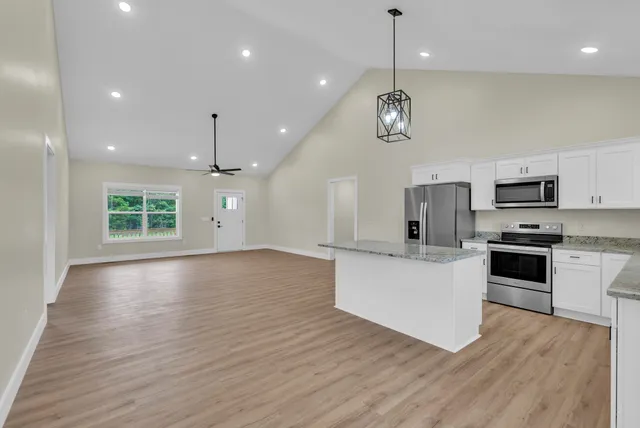 a view of kitchen with sink microwave refrigerator and stove with wooden floor