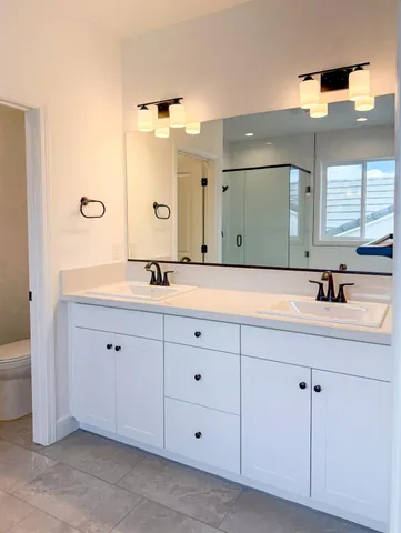 a bathroom with a double vanity sink and mirror