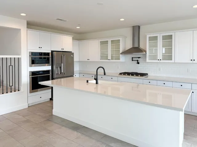 a kitchen with stainless steel appliances a refrigerator sink and cabinets