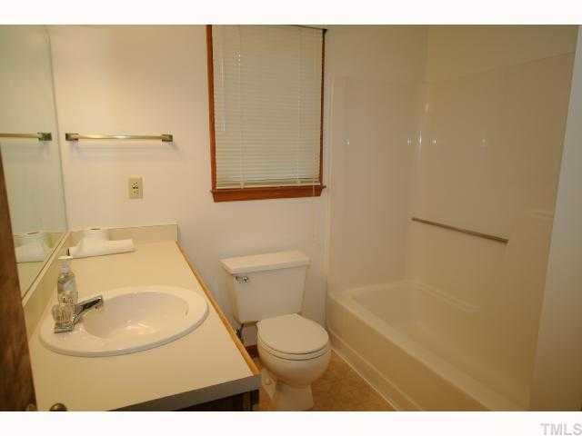 6804 Chamonix Place Raleigh, NC 27613 - Photo 7 of 12 a bathroom with a toilet a sink and mirror