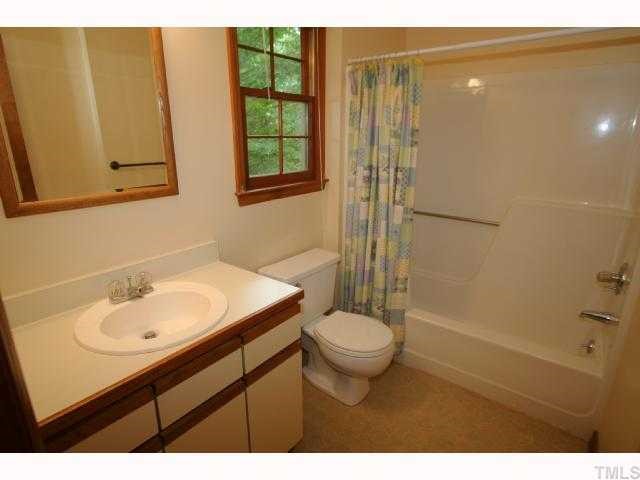 6804 Chamonix Place Raleigh, NC 27613 - Photo 10 of 12 a bathroom with a sink toilet a mirror and shower