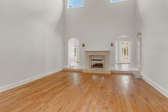a view of empty room with wooden floor and fireplace
