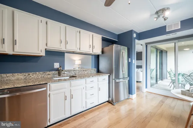 a kitchen with stainless steel appliances granite countertop a refrigerator sink and cabinets