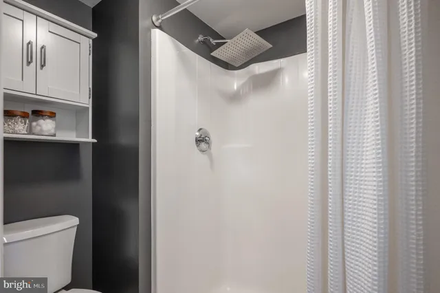 a bathroom with a toilet and a shower curtain