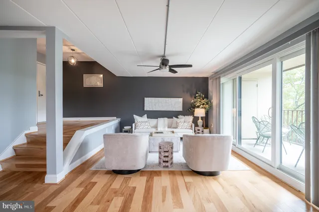 a living room with a couch and large window with wooden floor