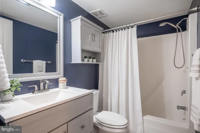 a bathroom with a sink vanity mirror and toilet