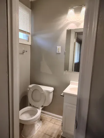 a white toilet sitting next to a bathroom sink and a vanity