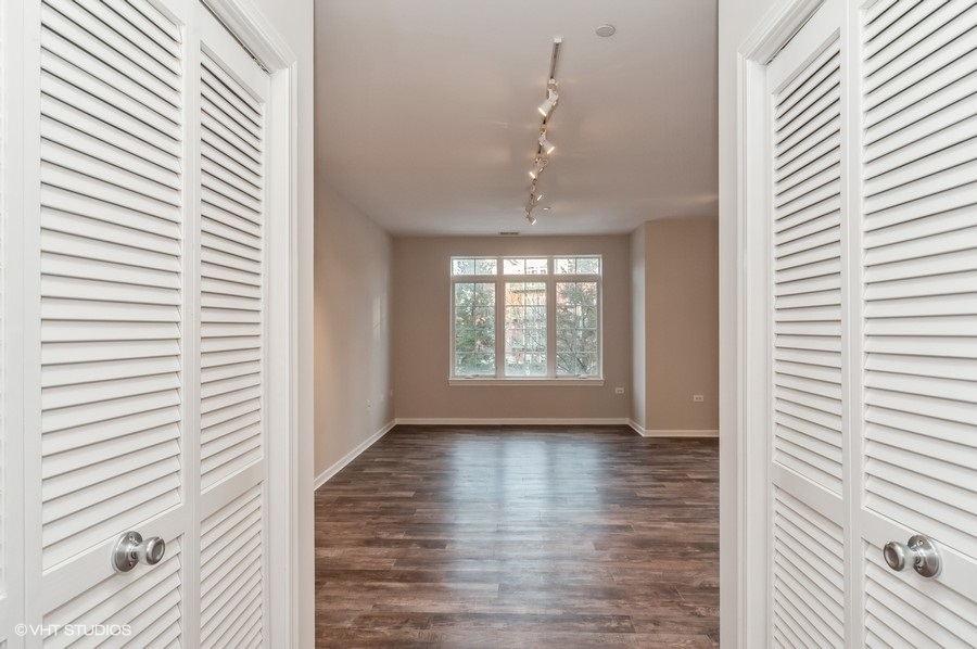 640 McHenry Road, Unit 203 Wheeling, IL 60090 - Photo 13 of 14 a view of an empty room with wooden floor and a window