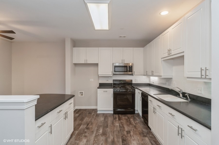 640 McHenry Road, Unit 203 Wheeling, IL 60090 - Photo 3 of 14 a kitchen with granite countertop a sink stove and refrigerator