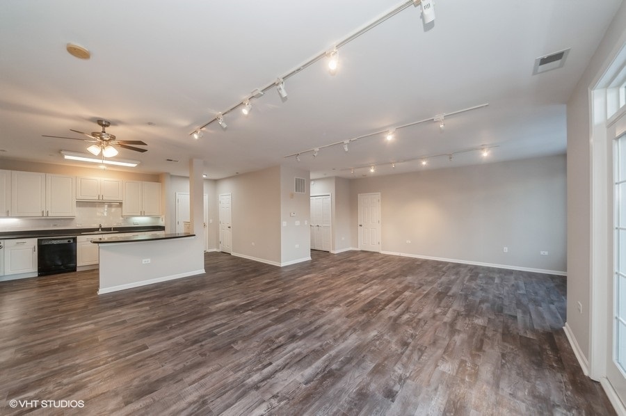 640 McHenry Road, Unit 203 Wheeling, IL 60090 - Photo 4 of 14 a large kitchen with kitchen island a stove a sink dishwasher and a refrigerator with wooden floor