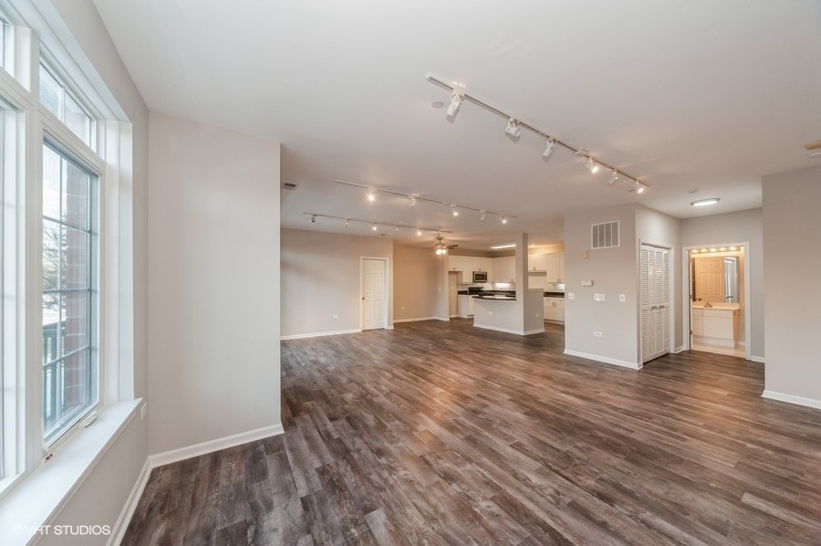 640 McHenry Road, Unit 203 Wheeling, IL 60090 - Photo 5 of 14 a view of empty room with wooden floor and windows
