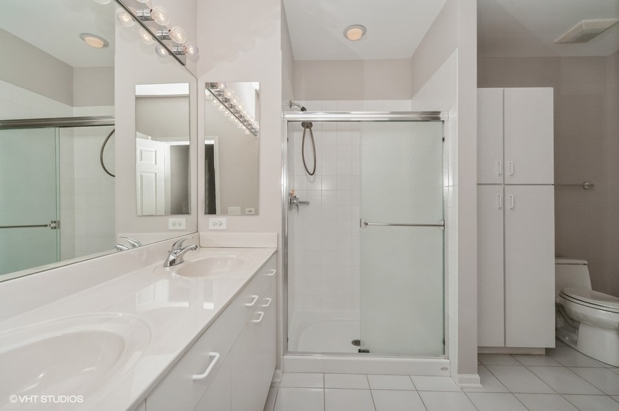640 McHenry Road, Unit 203 Wheeling, IL 60090 - Photo 9 of 14 a bathroom with a granite countertop sink a toilet and shower
