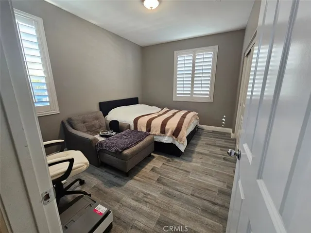 a bedroom with a bed and wooden floor