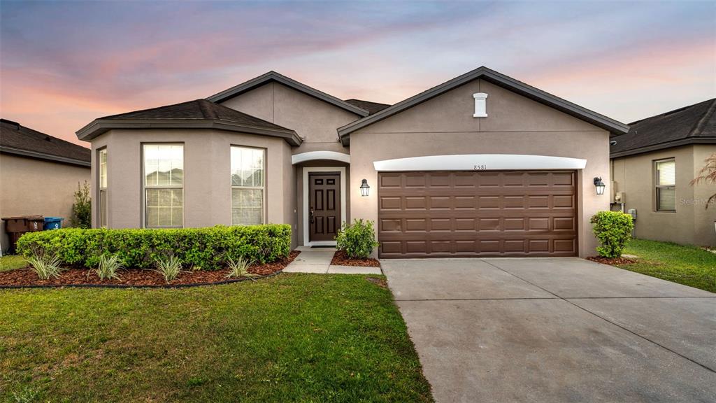 a front view of a house with a yard and garage