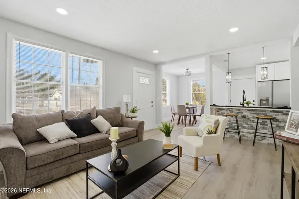 a living room with furniture wooden floor and a large window