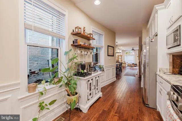 a kitchen with stainless steel appliances a stove a refrigerator and a wooden floor