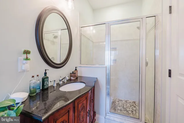 a bathroom with a granite countertop toilet a sink and a mirror