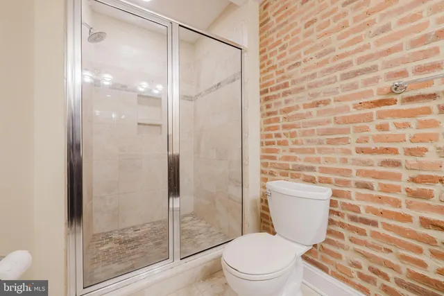 a en suite bathroom with a granite countertop shower a sink and wooden floor