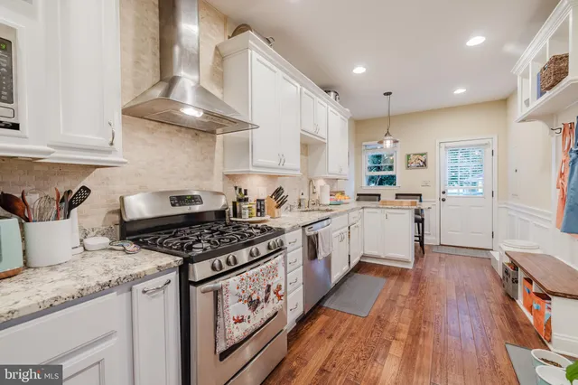 a kitchen with granite countertop stainless steel appliances a sink a counter space and cabinets
