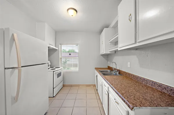 a kitchen with granite countertop a refrigerator and a sink