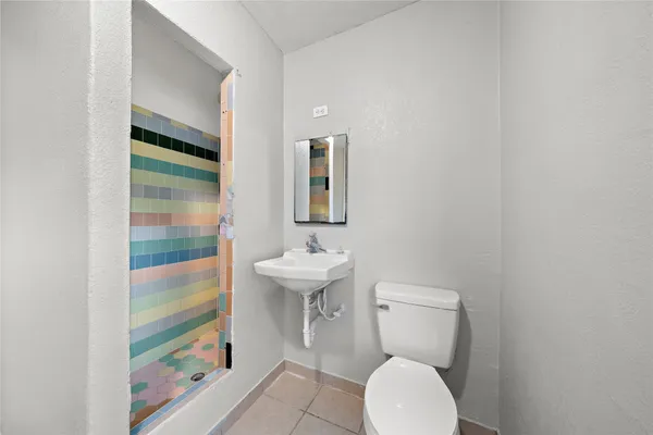 a bathroom with a toilet sink and mirror