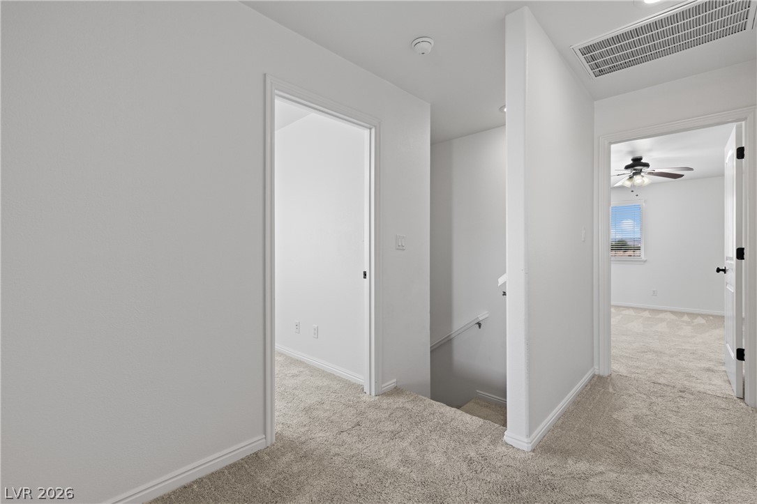 575 Gann Avenue Logandale, NV 89021 - Photo 40 of 75 A well-lit landing provides access to various rooms and a lower level via a carpeted stairway.