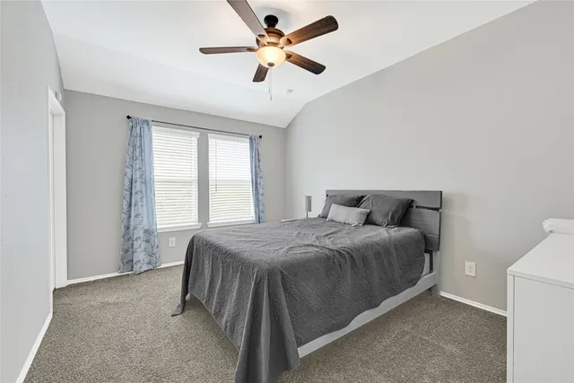 a spacious bedroom with a bed and a ceiling fan